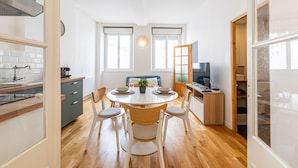 Eine moderne Küche mit Essbereich, Holzboden und großen Fenstern.