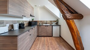Een moderne keuken met houten kastjes, een magnetron, broodrooster, spoelbak en vaatwasser.