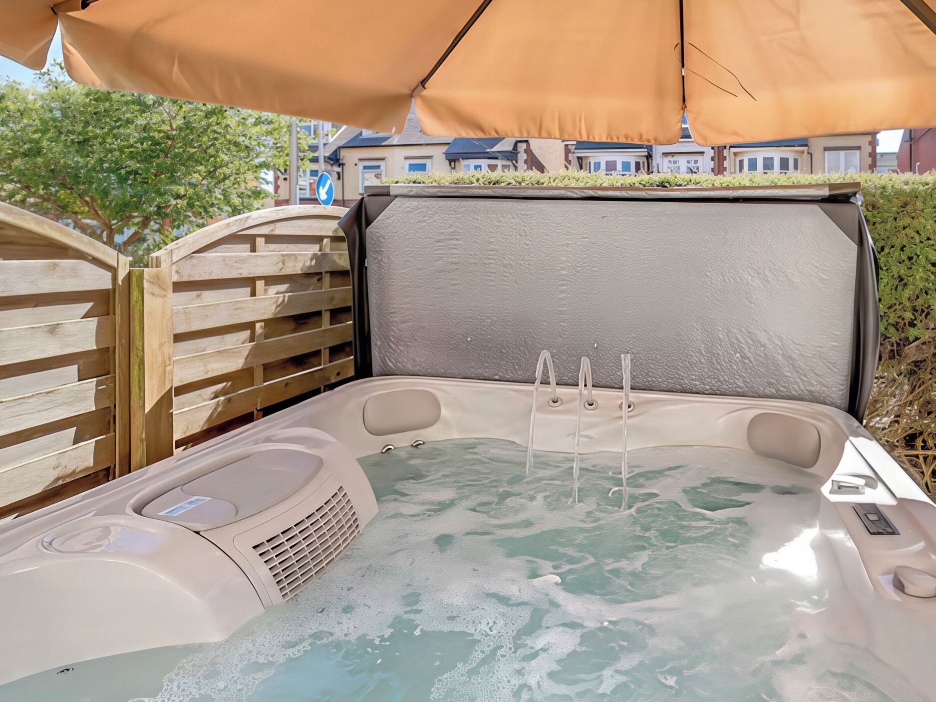 Ett bubbelbad med ett trästaket och ett beigefärgat tak.