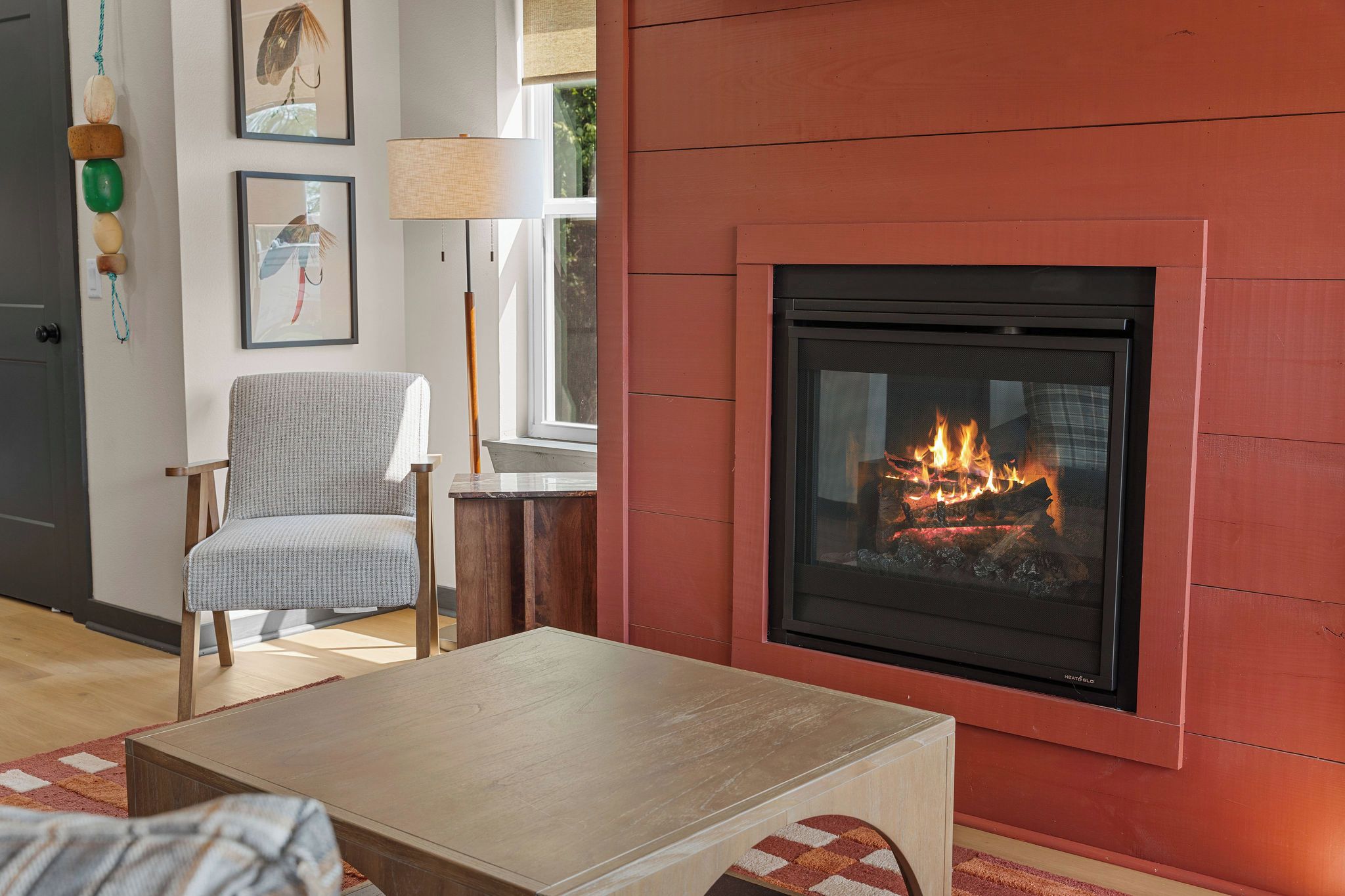 Una sala de estar con chimenea, un sofá, una mesa de centro y una lámpara.