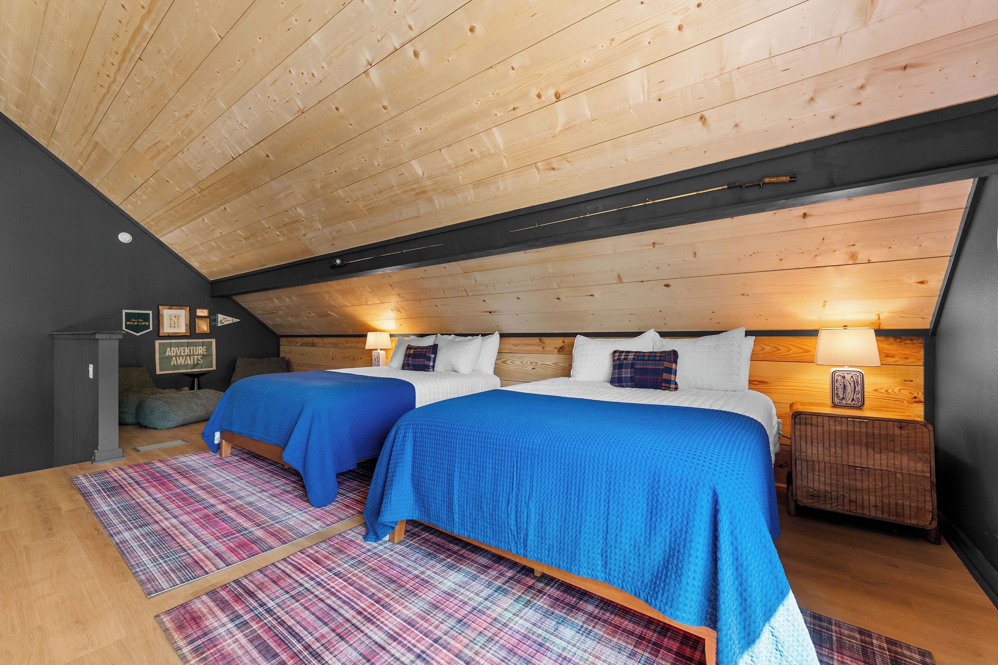 Une chambre avec deux lits, un plafond en bois et un tapis à carreaux.