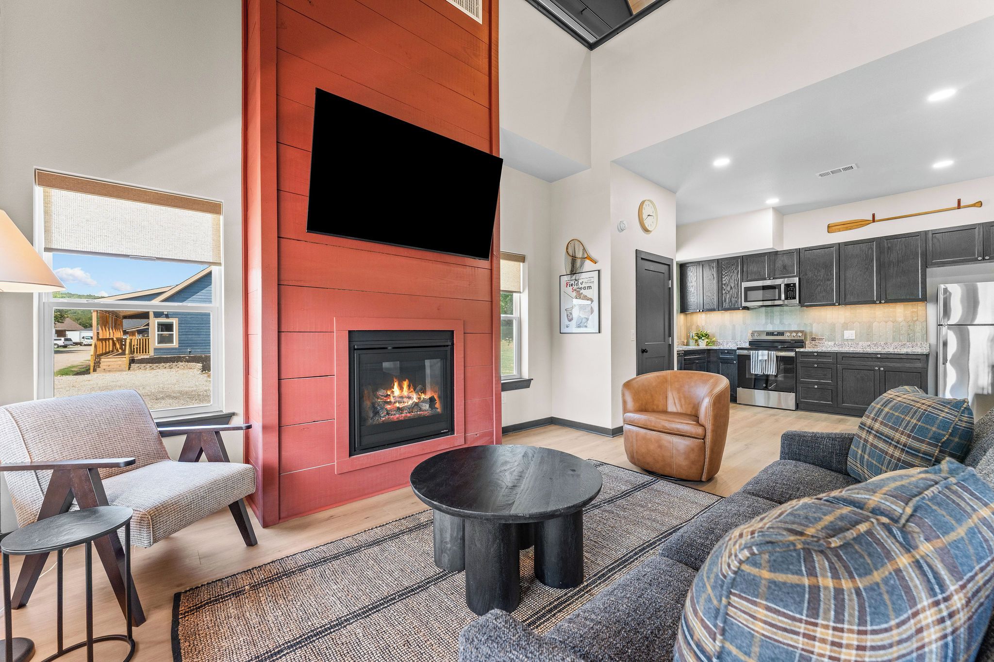A modern living room with a fireplace, a dining area, and a kitchen.