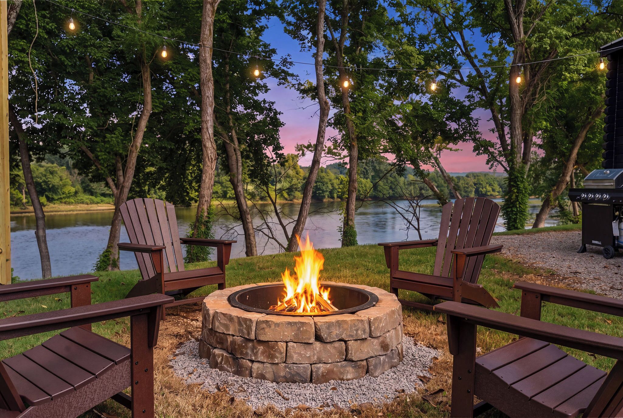 Un foyer entouré de fauteuils Adirondack, un barbecue et une vue sur le lac.