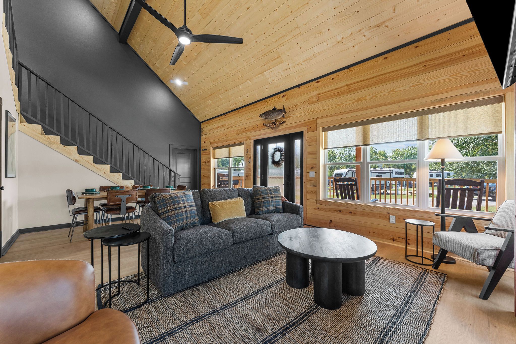 Ein modernes Interieur mit Treppe, einer Sofagarnitur, einem Couchtisch und Blick ins Freie.