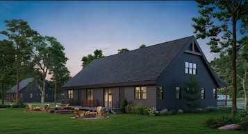 Una casa moderna con techo oscuro, ventanas amplias y un césped bien cuidado.