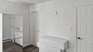 A room with a white wardrobe, a white bench, and a white door. - Brand New Private Guest House (Miami)