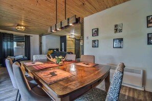 Une table de salle à manger en bois, agrémentée de sets de table, de chaises et d’un élément décoratif central.