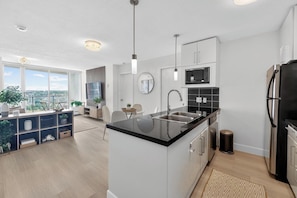Una cocina moderna con una isla central, electrodomésticos de acero inoxidable y un comedor con vistas.