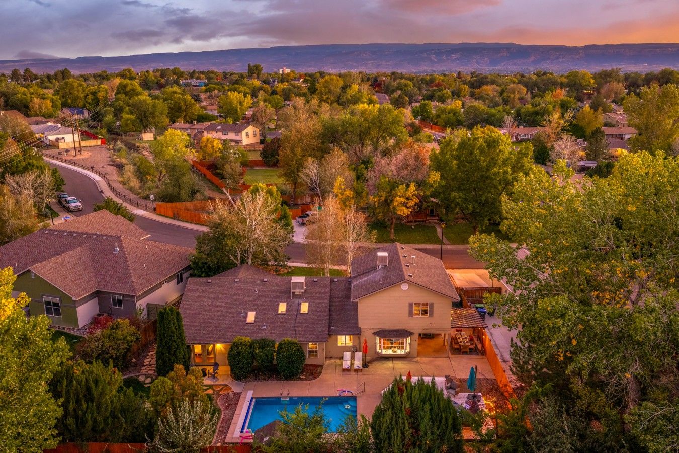 Zona residencial con casas, una piscina y un paisaje montañoso al fondo.