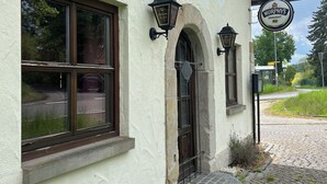 Un edificio con fachada blanca, un letrero que dice 'Murphy's Draught' y un camino empedrado que lleva a la entrada.