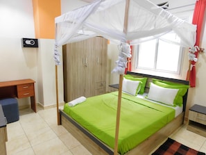 Une piĂšce comprenant un lit, un bureau, une armoire et une fenĂȘtre.