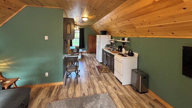 Uma cabana aconchegante com cozinha, sala de jantar e ventilador de teto.