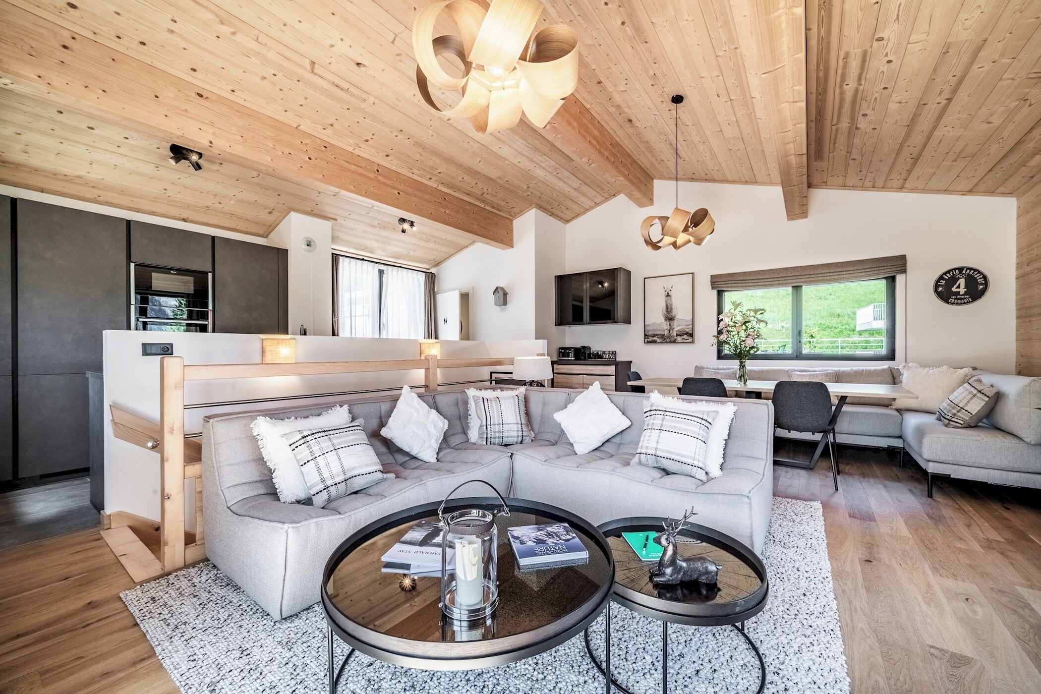 Een moderne woonkamer met een modulaire bank, een salontafel en een eethoek.