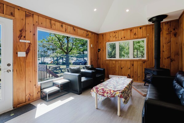 A wooden-paneled room with a sofa, a table, and a fireplace.