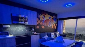 Een moderne keuken met een eethoek, een grote televisie en uitzicht over de stad.