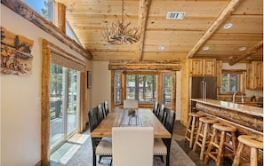 A wooden interior with a dining table, chairs, and a bar area. - Family Cabin, 2 Game Rooms, Basketball Court, Spa (Big Bear Lake,)