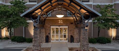 A building entrance with a stone facade, a number '31' above the door, and a covered walkway.