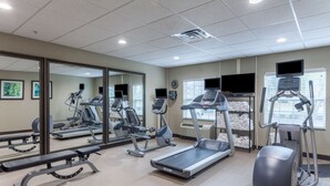 A gym with treadmills, elliptical machines, and weight benches.