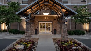 A building entrance with a stone facade, a number '31' above the door, and a covered walkway.