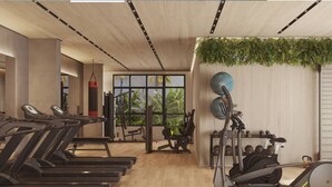 Un gimnasio moderno con cintas de correr, máquinas de pesas y un amplio ventanal con vistas a zonas verdes.