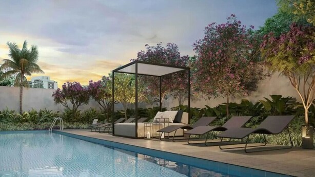 Piscina con sillones de descanso y zona de estar techada.