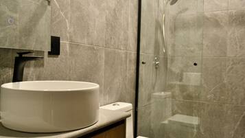 Een douche, handdoeken, zeep, shampoo