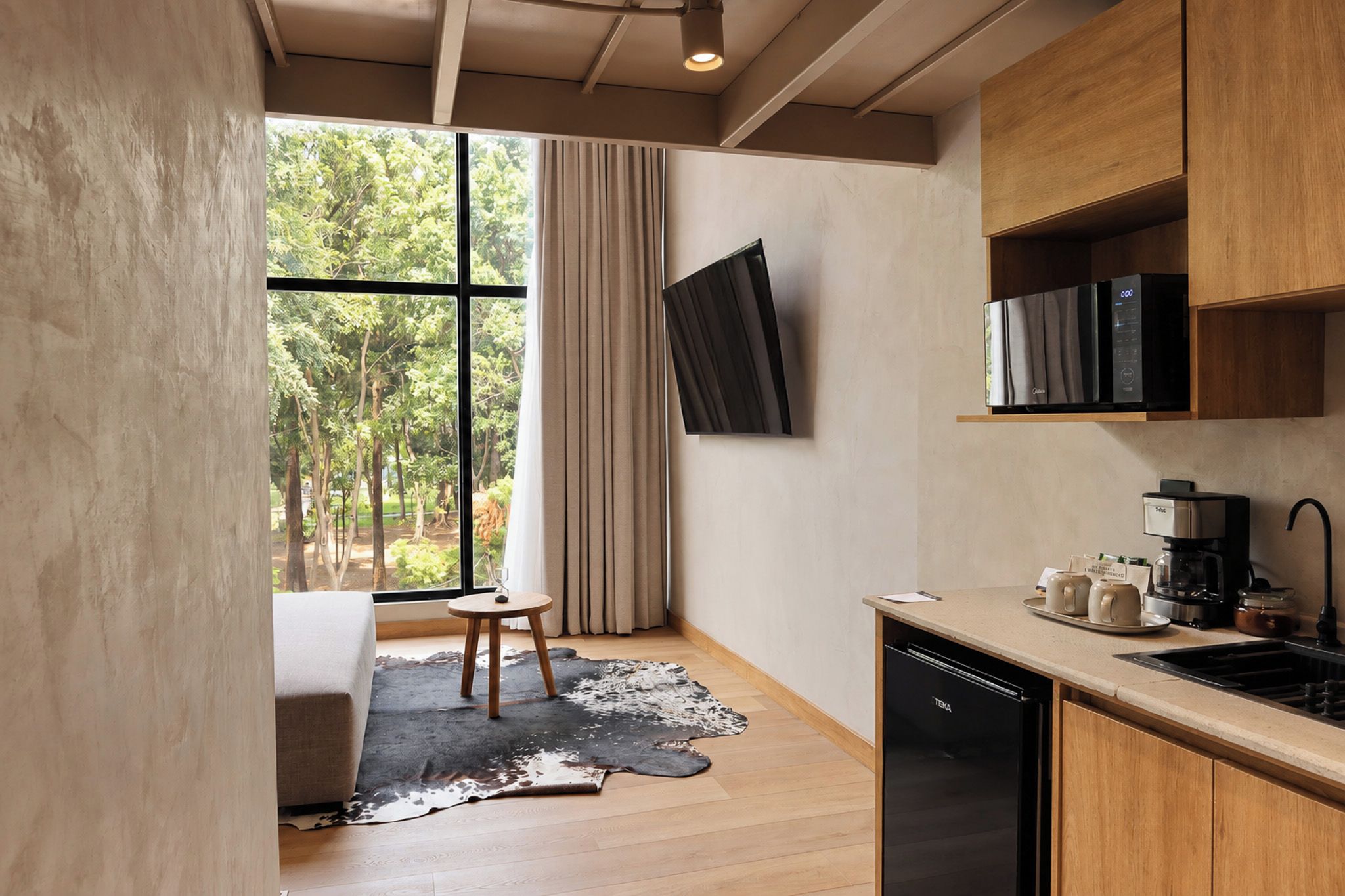 Een moderne keuken met een ingebouwde vaatwasser, een koffieapparaat en een flatscreen tv aan de muur bevestigd.