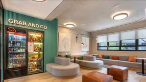 Un interno moderno con un frigorifero 'Grab and Go', zone relax e ampie finestre.