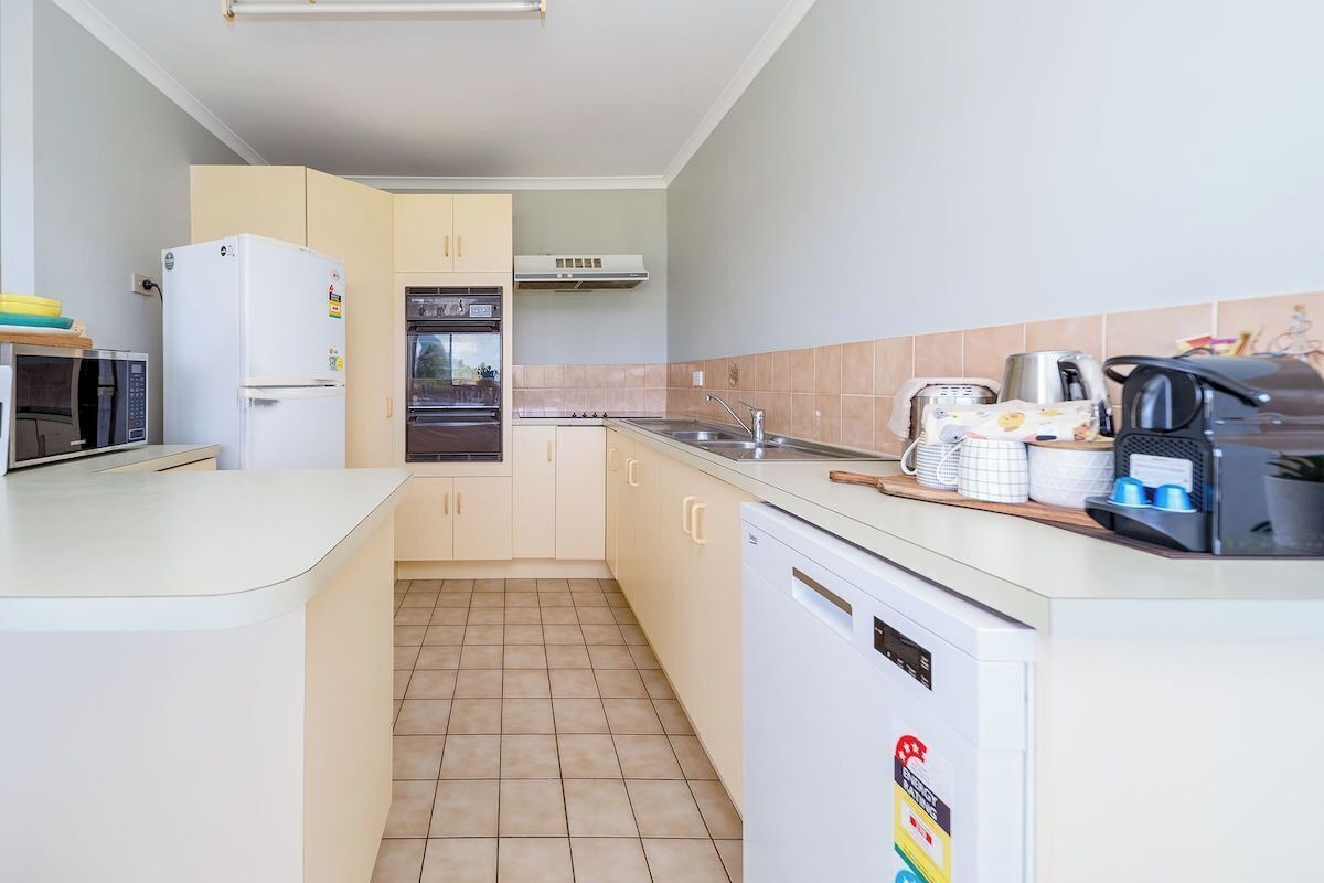 A compact kitchen with a microwave, refrigerator, oven, and dishwasher.