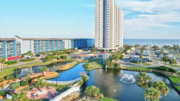 Un hotel con varias edificaciones, una zona de estacionamiento y una fuente.