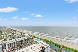 Ein Küstenhotel mit mehreren Gebäuden, einem Strand und einem Schwimmbad.