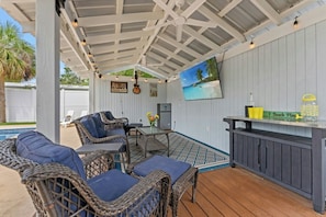 A covered patio area with wicker furniture, a table, and a bar counter. - Robin's Nest - Private Pool Retreat (North Myrtle Beach)
