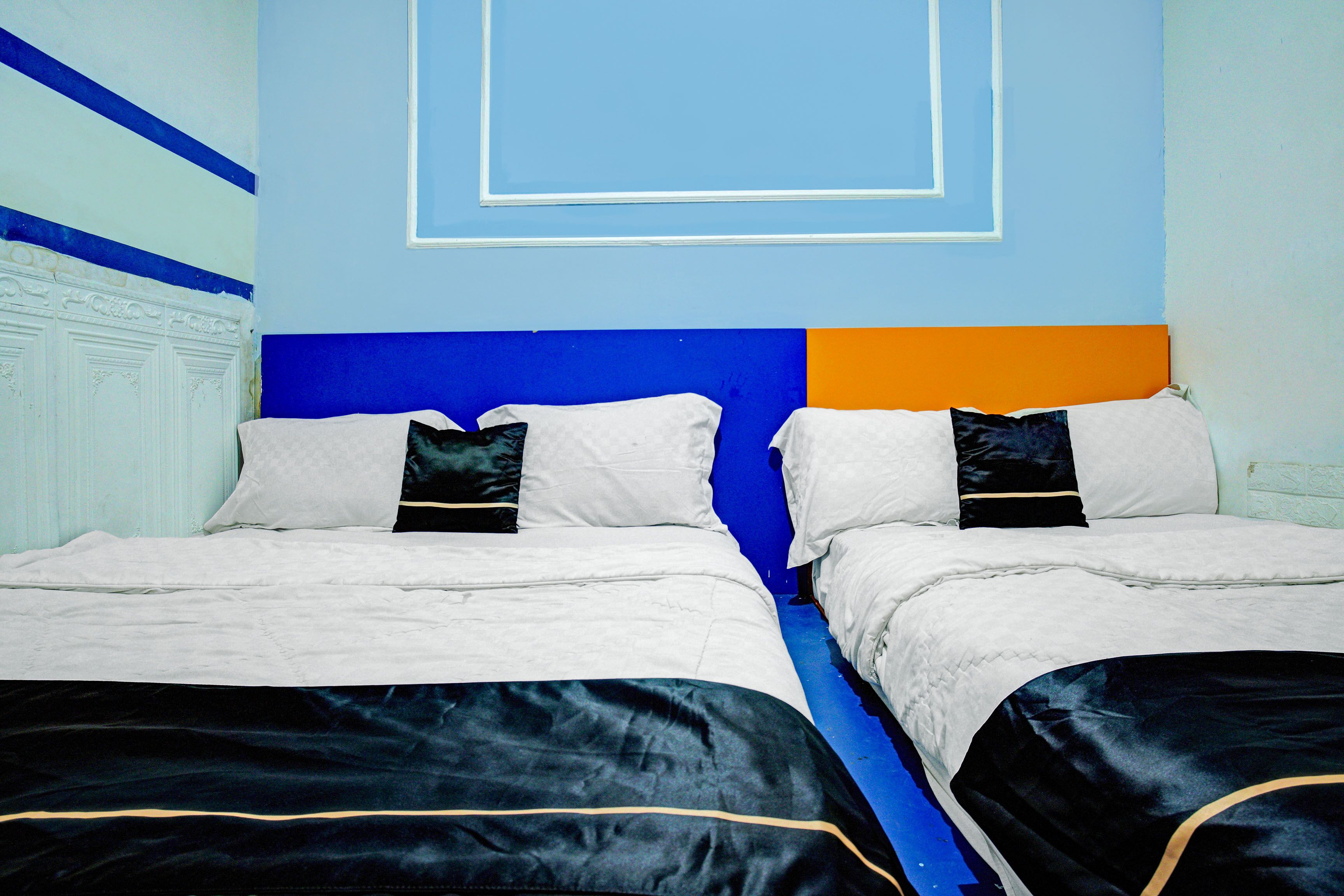 A double bed with a blue headboard and white bedding.
