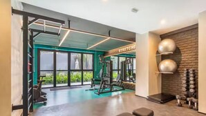 Une salle de sport équipée de matériel d’exercice, d’un banc et d’un mur avec des haltères.
