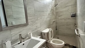 A modern bathroom with a sink, toilet, and shower. - Casa Completa: Confort, Alberca y Asador. (Fraccionamiento El Chaparral)