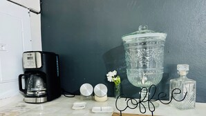A kitchen counter with a coffee maker, a water dispenser, and a decorative sign spelling 'coffee'. - Casa Completa: Confort, Alberca y Asador. (Fraccionamiento El Chaparral)