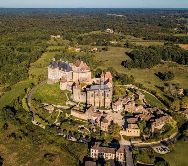 An aerial view of a historic castle with a fortified structure, surrounded by a village with traditional architecture. - Le Brame - Three Bedroom Villa, Sleeps 6 (Dévillac)