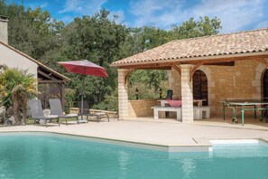A pool area with lounge chairs, a covered patio, and a stone building with arches. - Le Brame - Three Bedroom Villa, Sleeps 6 (Dévillac)