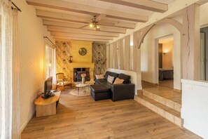 A cozy living room with a fireplace, wooden flooring, and a sofa. - Le Brame - Three Bedroom Villa, Sleeps 6 (Dévillac)
