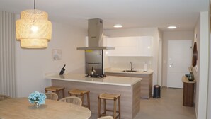 A modern kitchen with a central island, stainless steel appliances, and a hanging light fixture. - Modern 2 Bed 2 Bath apartment in Playa Nueva Romana - Beach, PGA Golf and Pools (La Caña)