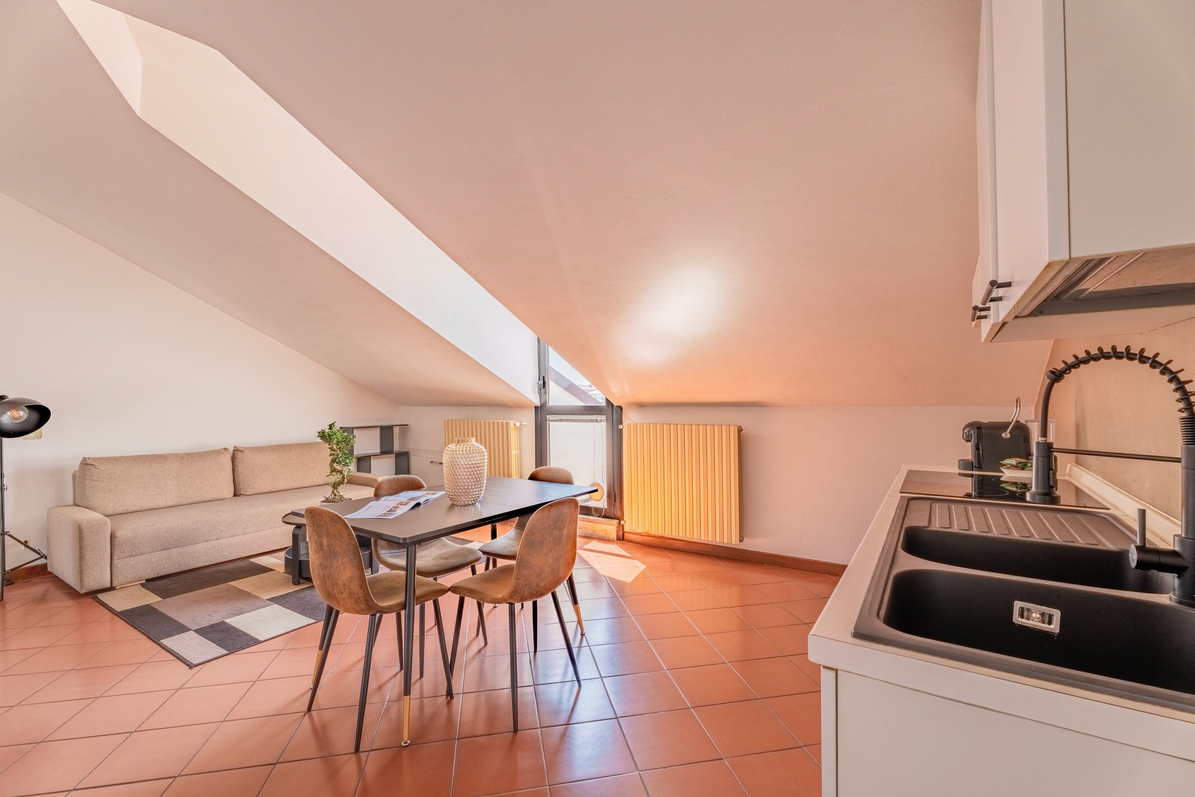 Une cuisine moderne avec un coin repas, un canapé et un radiateur.