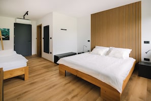 A modern bedroom with a wooden bed, a bench, a wall-mounted air conditioner, and a wooden slat wall panel.