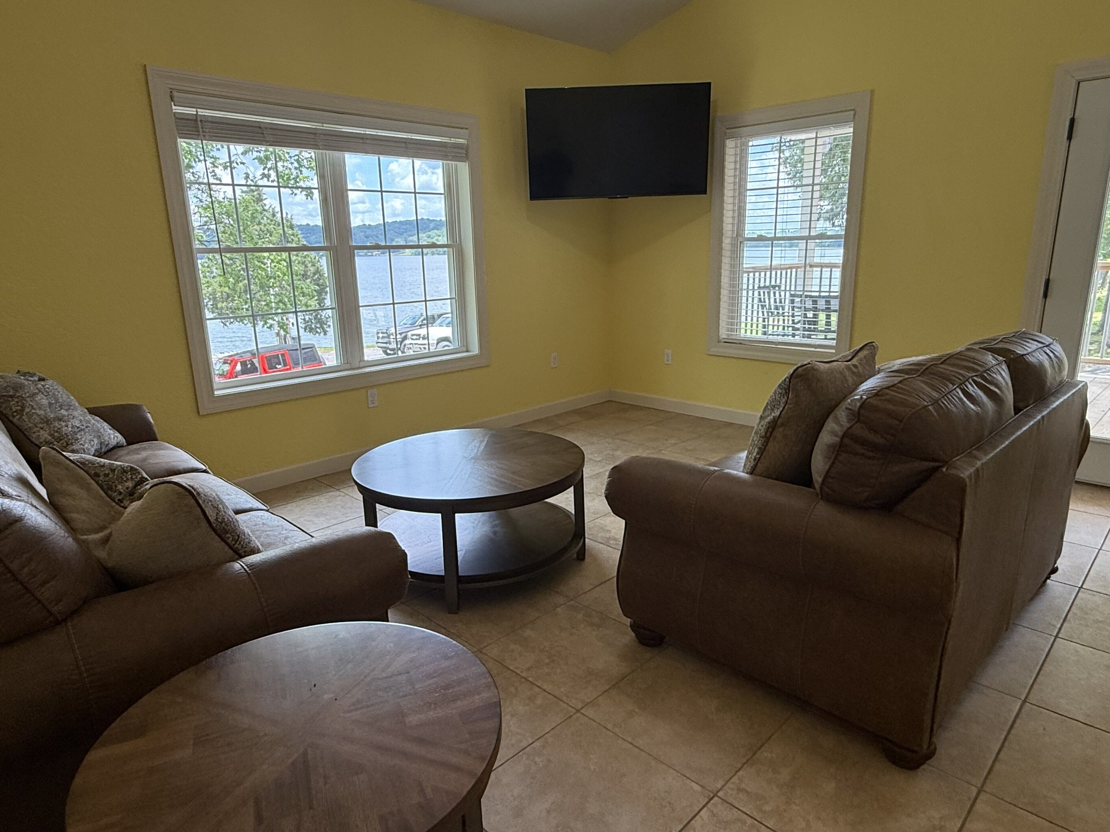 A living room with two sofas, a coffee table, and a TV mounted on the wall.