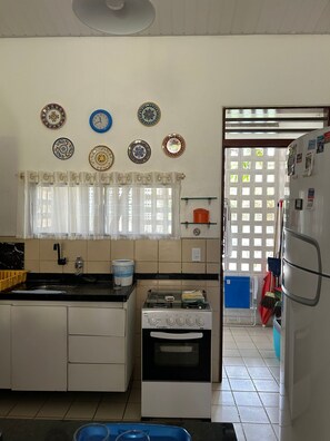 A kitchen with a stove, sink, and refrigerator.