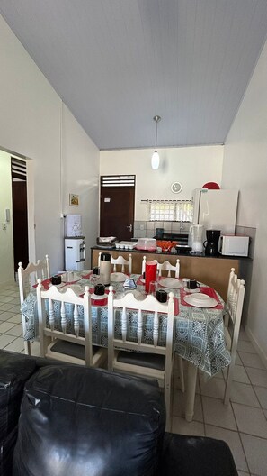 Un espacio habitable compacto con comedor, kitchenette y una pequeña zona de estar.