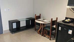 Eine moderne Küche mit Kühlschrank, einem Esstisch mit Stühlen und einer integrierten Sitzbank.