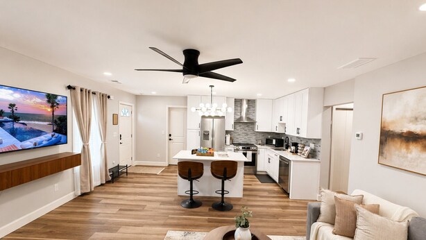 A modern living room with a TV, a ceiling fan, a coffee table, and a sofa. - Cozy & Spacious 2BR Private Suite Near ATL Airport (Atlanta)