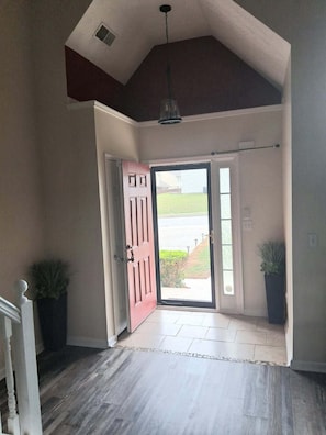 A spacious entryway with a wooden floor, a red door, and a view of the outdoors. - Spacious 4-bedroom, 2.5 bath home in beautiful Fairburn with spacious living (Fairburn)