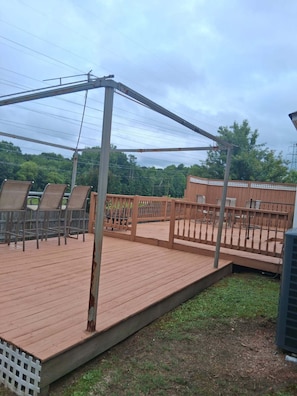 A wooden deck with metal railings, surrounded by a white picket fence, and a grassy area. - Spacious 4-bedroom, 2.5 bath home in beautiful Fairburn with spacious living (Fairburn)