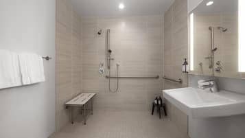 A modern bathroom with a shower, a sink, and a mirror.